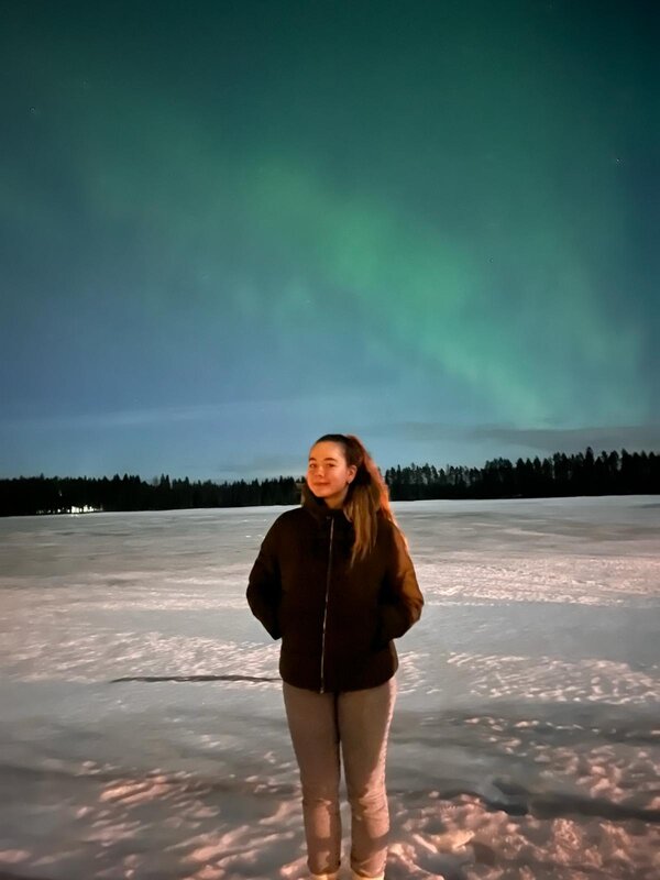 Eine Frau steht im Schnee unter dem Nordlicht. | © Luisa Fischer