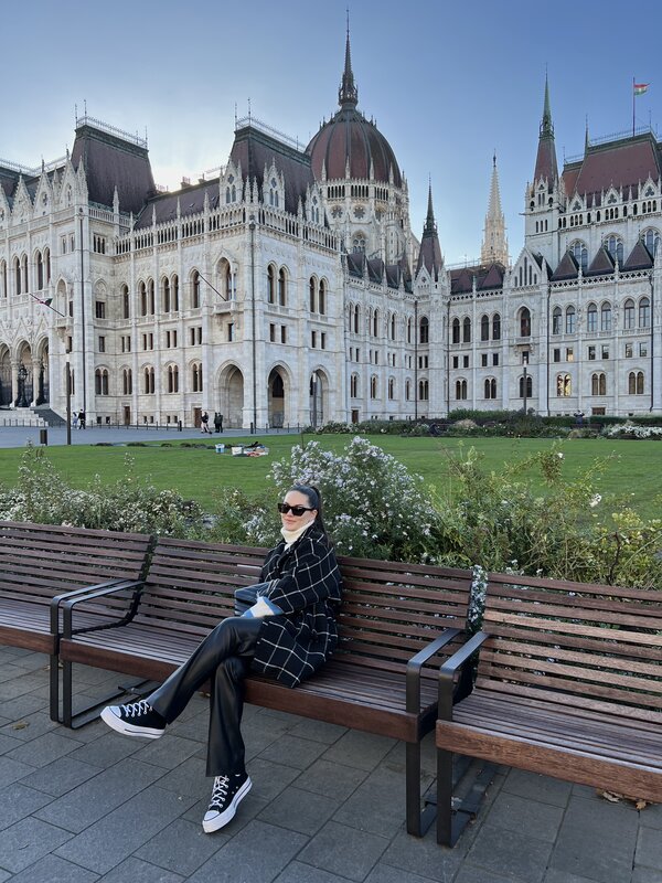 Eine Frau sitzt auf einer Bank, hinter ihr befindet sich ein Schloss. | © Melanie Sadler